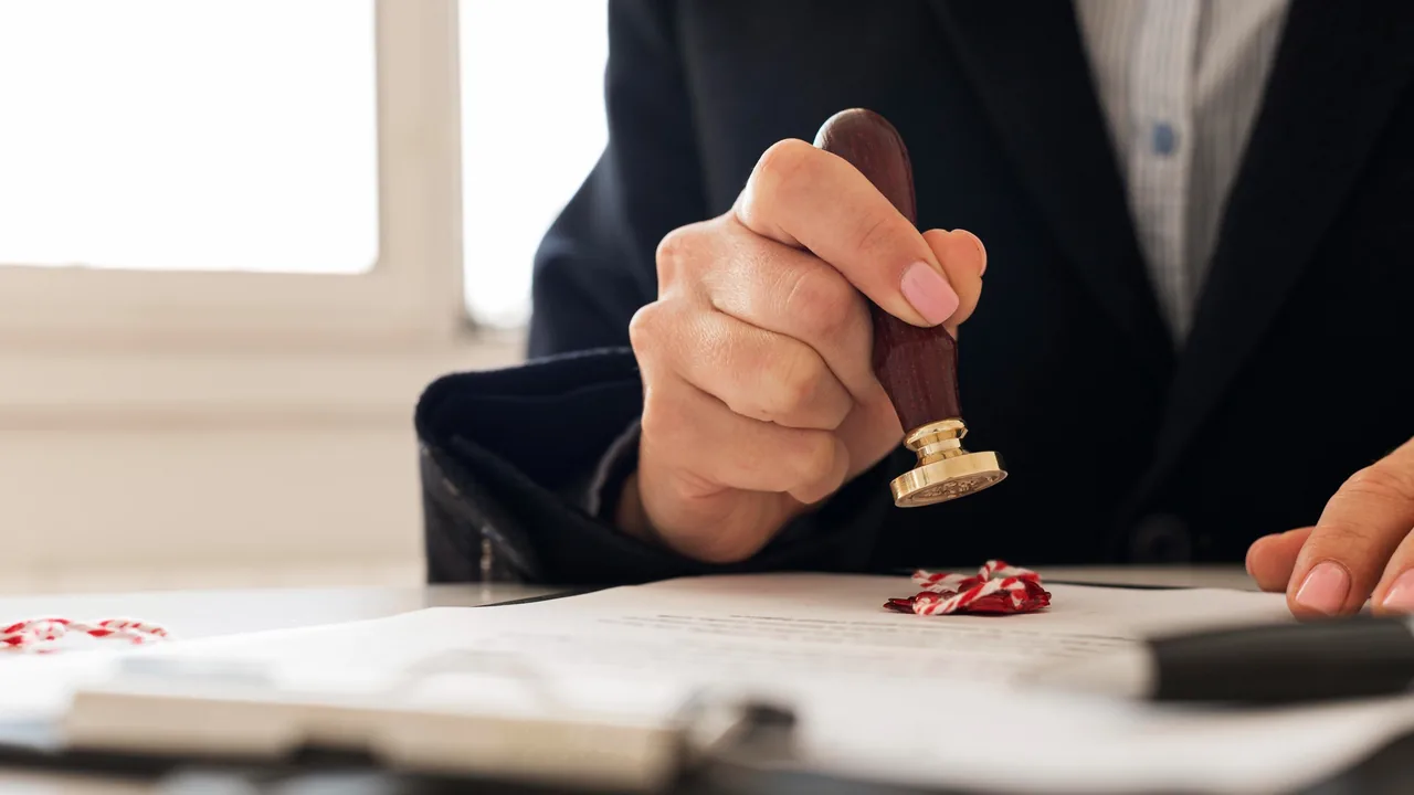 Medewerker zet een zegelstempel op een officieel document