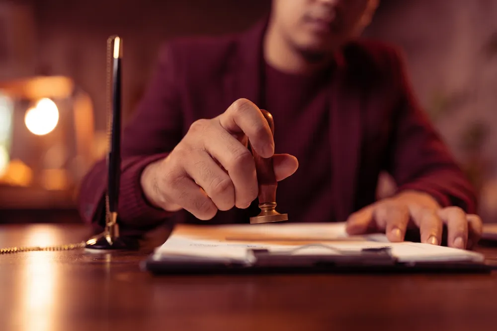 Vakreviewer in ons kantoor zet de stempel onder een afgeronde beëdigde vertaling